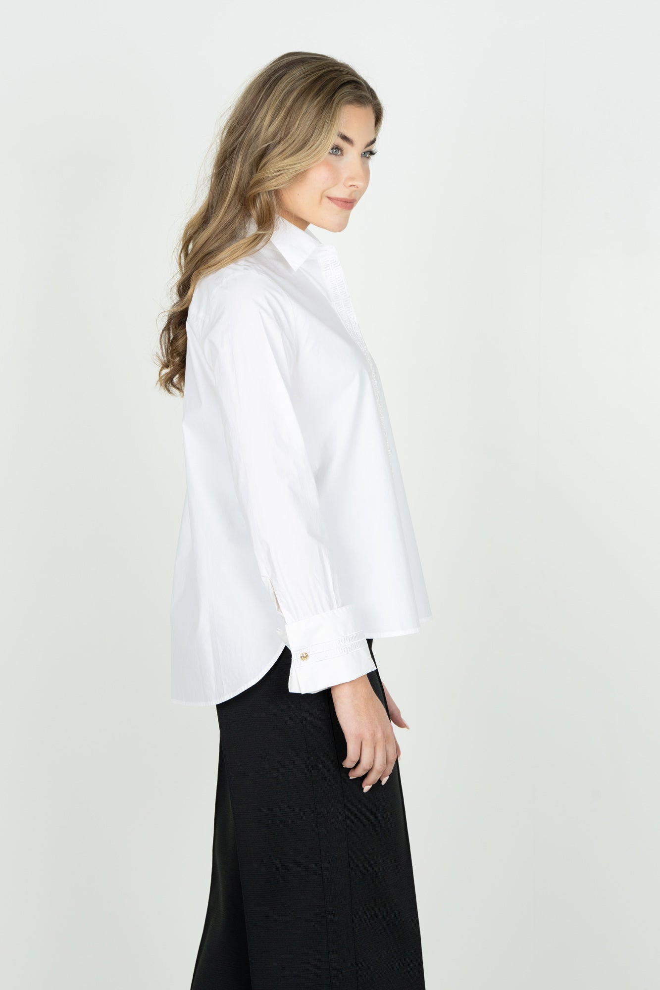 Woman wearing Emily McCarthy Classic Oxford white button-down shirt with black skirt, side view